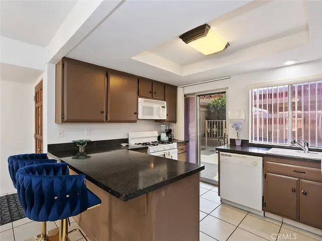 a kitchen with a sink counter top space and living room view
