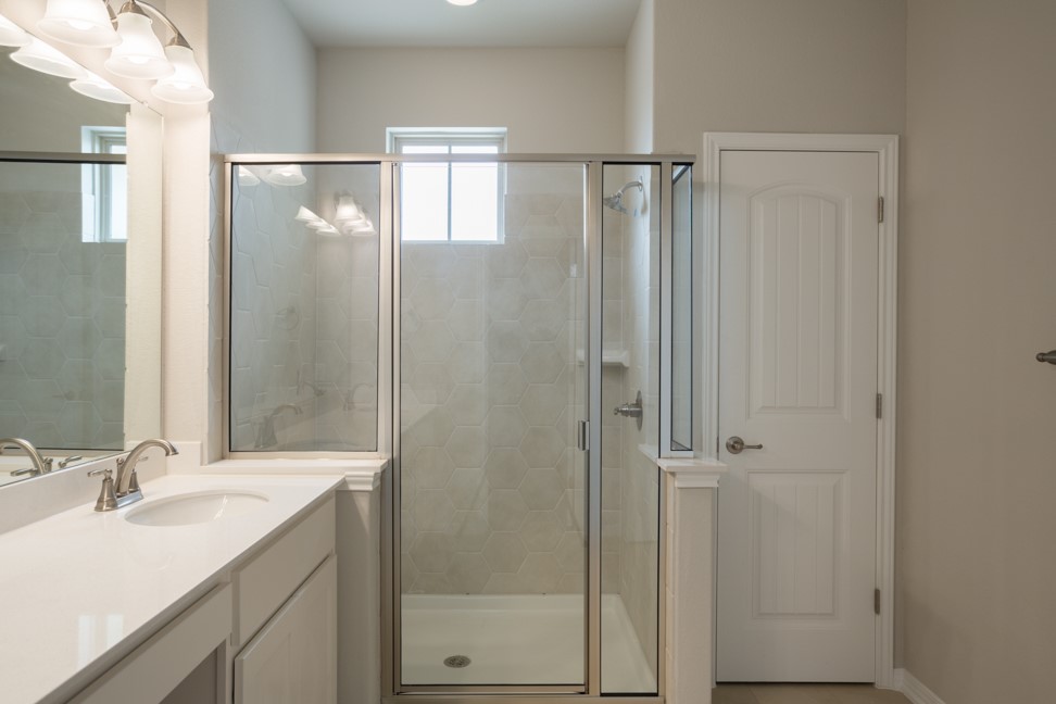 1600 Harwell Loop Kyle, TX 78640 - Photo 21 of 30 a bathroom with a shower sink and mirror