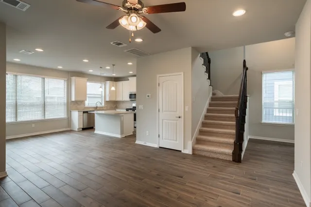 a view of a kitchen with wooden floor and electronic appliances