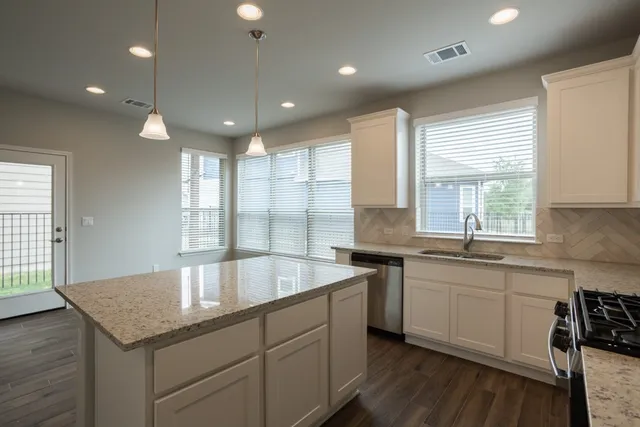 a kitchen with center island a sink dishwasher a stove and a refrigerator with wooden floor