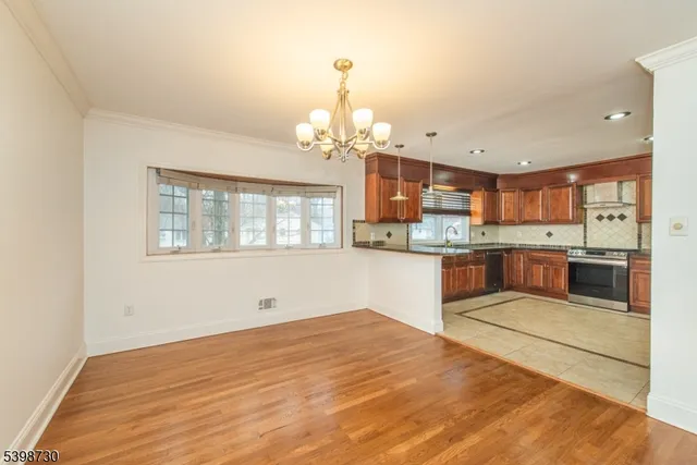 a kitchen with granite countertop white cabinets and stainless steel appliances