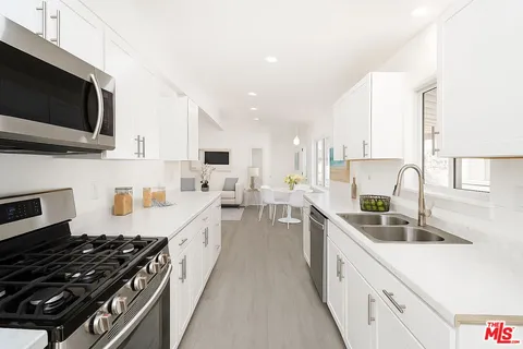 a large kitchen with stainless steel appliances granite countertop a lot of counter space a sink and a stove