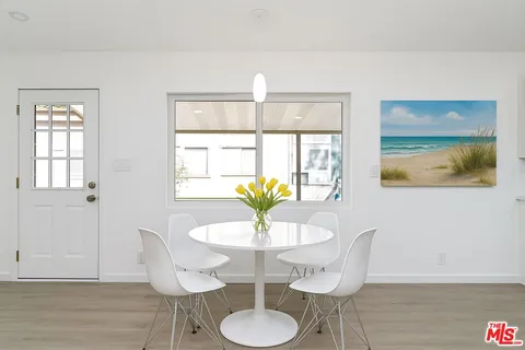 a view of a dining room with furniture a chandelier and wooden floor