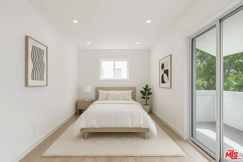 a bedroom with a large bed and a chandelier