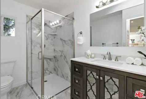 a bathroom with a granite countertop sink mirror a toilet and a bathtub