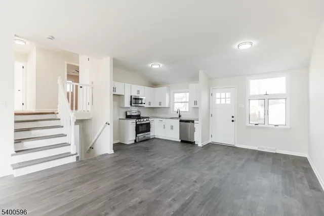 a view of a kitchen with wooden floor and windows