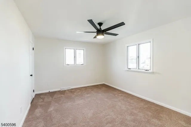 an empty room with a window and a fan