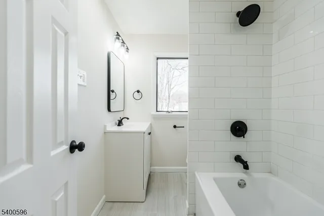 a bathroom with a tub sink and mirror
