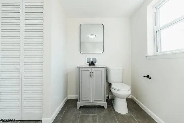 a bathroom with a toilet sink and mirror