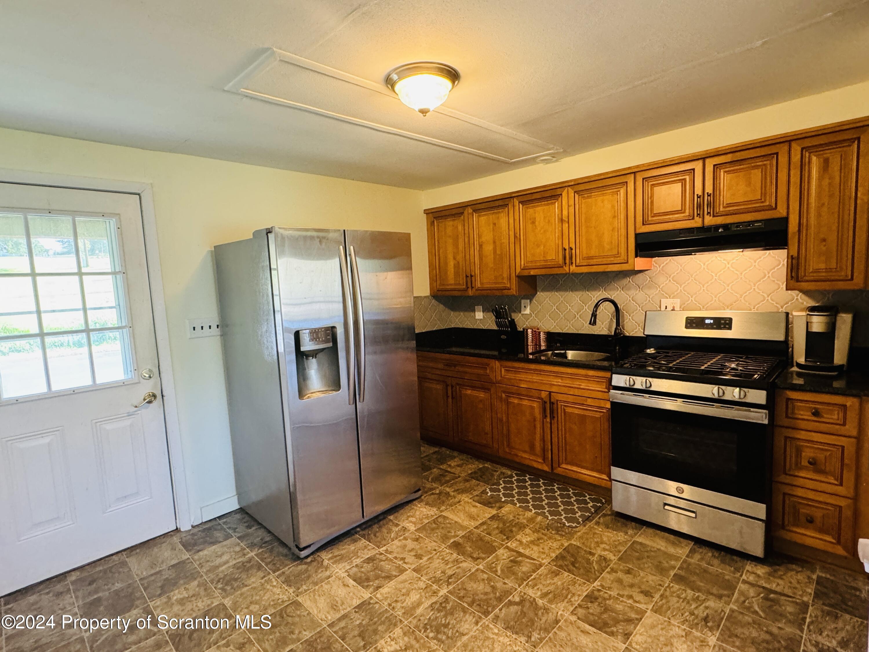 1590 State Rte 4002 Mehoopany, PA 18629 - Photo 4 of 38 a kitchen with stainless steel appliances granite countertop a refrigerator stove and sink