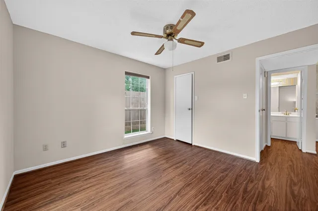 a view of a livingroom with wooden floor and a ceiling fan