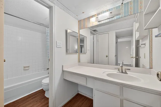 a bathroom with a sink double vanity granite tub shower and a mirror
