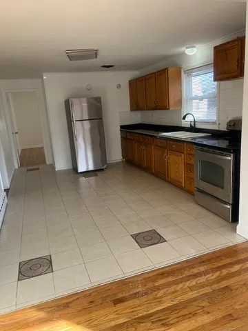 a kitchen with granite countertop a sink cabinets and stainless steel appliances