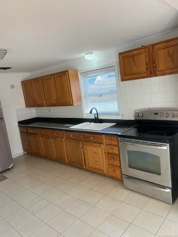 a kitchen with granite countertop a sink and a stove