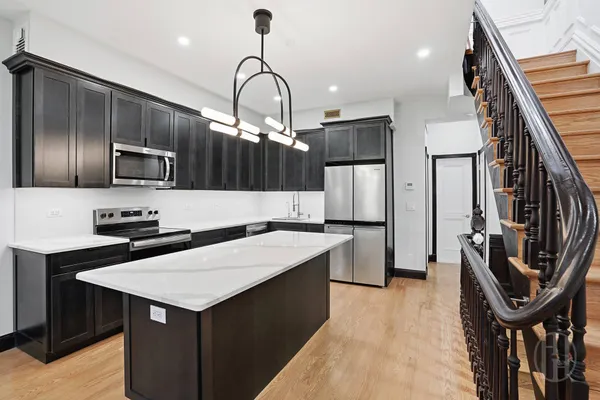 a kitchen with kitchen island a sink stove and refrigerator