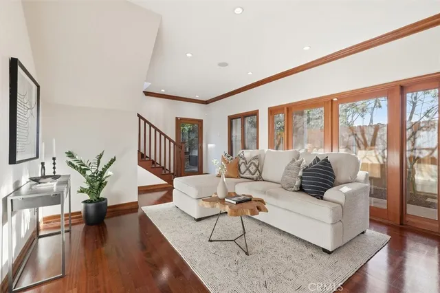 a spacious bedroom with a large bed a chandelier and windows