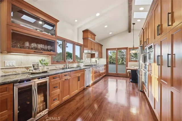 a kitchen with granite countertop stainless steel appliances a sink and a window