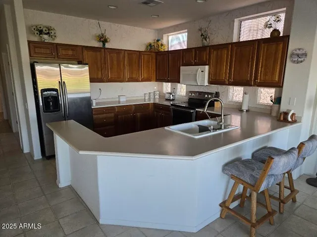 a kitchen with stainless steel appliances granite countertop a sink a refrigerator and a stove