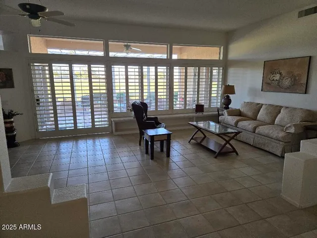 a living room with furniture and a floor to ceiling window