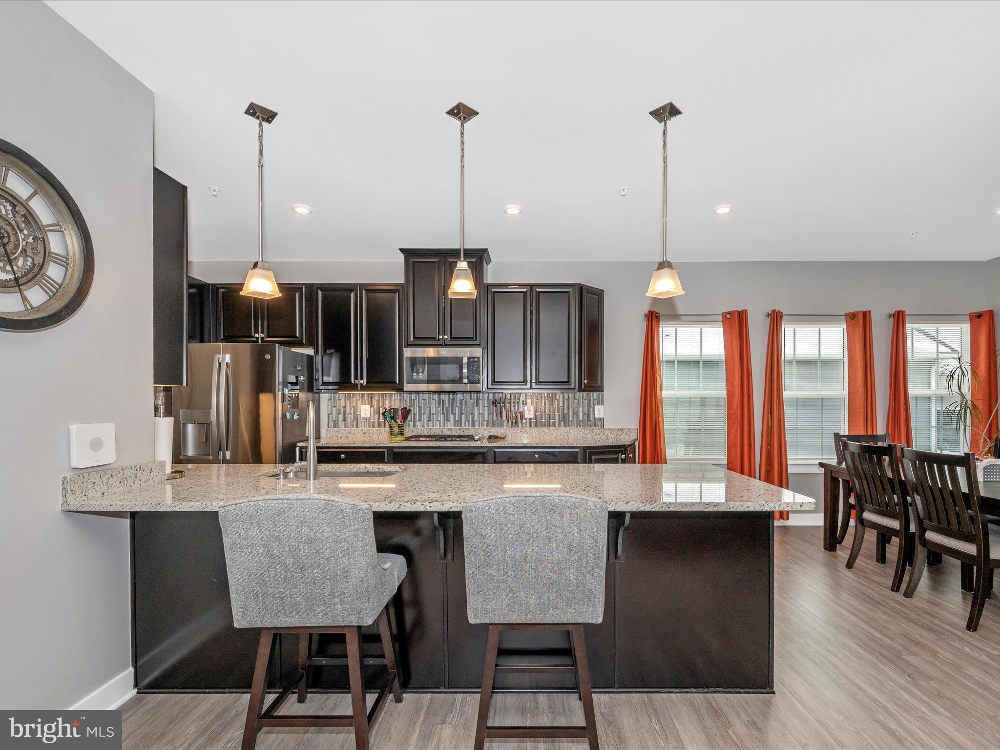 6649 Ballenger Run Boulevard Frederick, MD 21703 - Photo 7 of 42 a kitchen with stainless steel appliances granite countertop a kitchen island a stove and a wooden floors