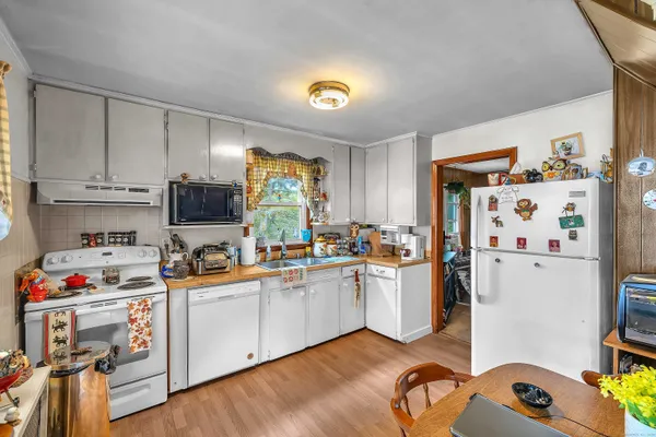 a kitchen with a refrigerator a stove a sink and wooden floor