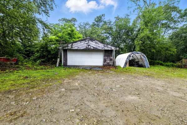 a view of a house with a yard and large tree
