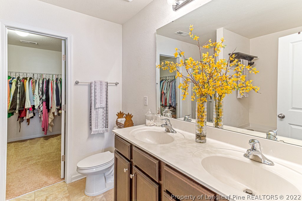 448 Botanical Court Bunnlevel, NC 28323 - Photo 22 of 37 a bathroom with a granite countertop toilet sink and mirror