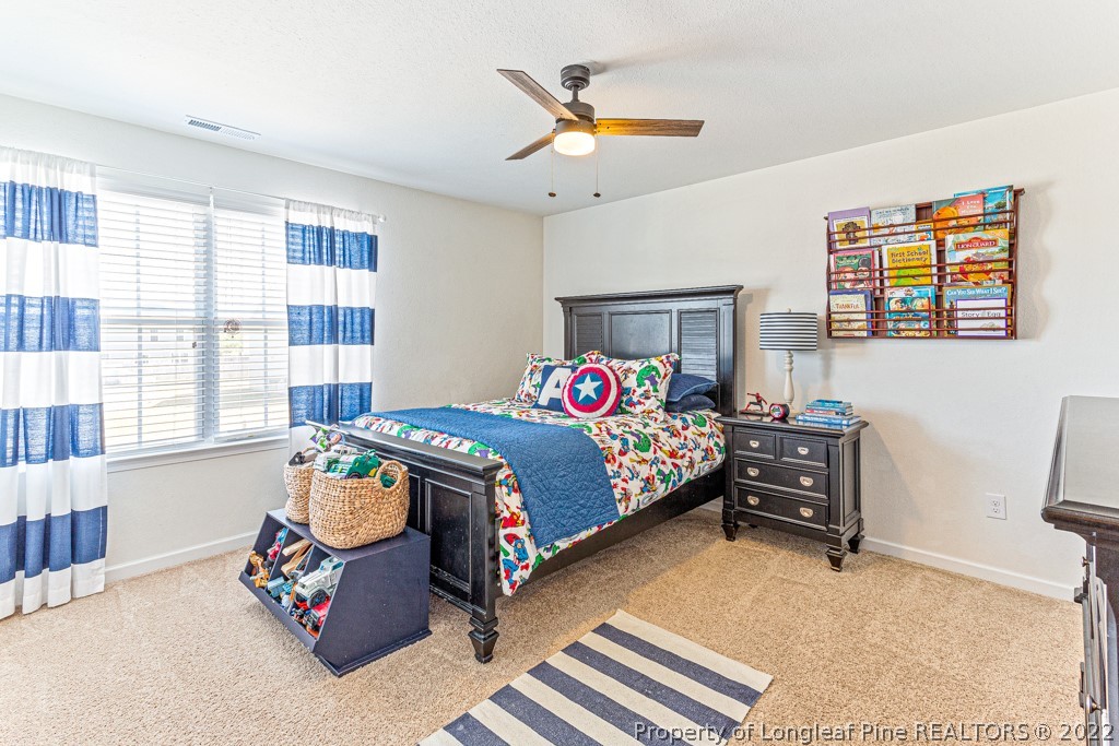 448 Botanical Court Bunnlevel, NC 28323 - Photo 26 of 37 a bedroom with a bed and a chandelier
