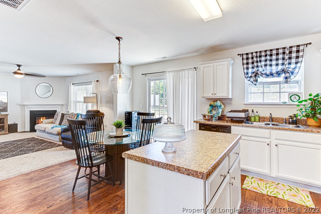 448 Botanical Court Bunnlevel, NC 28323 - Photo 6 of 37 a kitchen with a stove a refrigerator a dining table and chairs