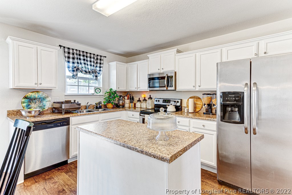 448 Botanical Court Bunnlevel, NC 28323 - Photo 7 of 37 a kitchen with granite countertop a refrigerator a sink a stove a microwave and island
