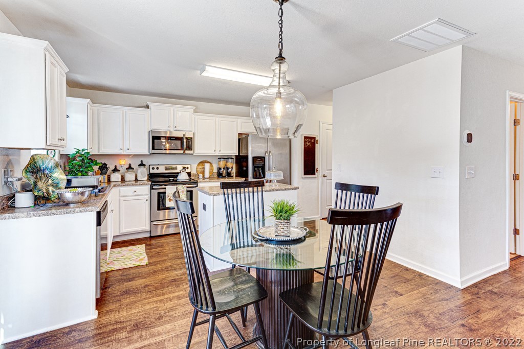 448 Botanical Court Bunnlevel, NC 28323 - Photo 10 of 37 a dining room filled chandelier and wooden floor