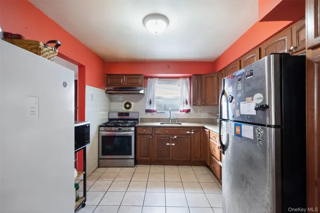 a kitchen with stainless steel appliances granite countertop a refrigerator and a stove