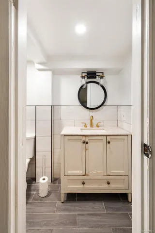 a bathroom with a granite countertop sink and a mirror