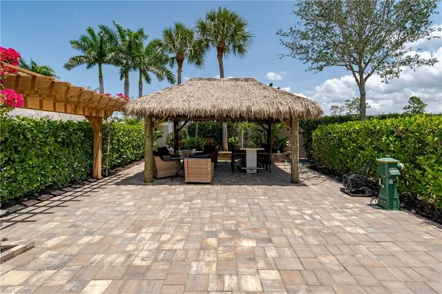 a view of a patio with a table and chairs under an umbrella