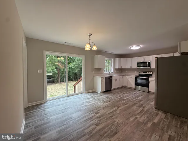 a kitchen with granite countertop stainless steel appliances a sink and counter space