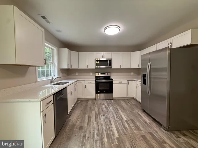 a kitchen with a sink cabinets and stainless steel appliances
