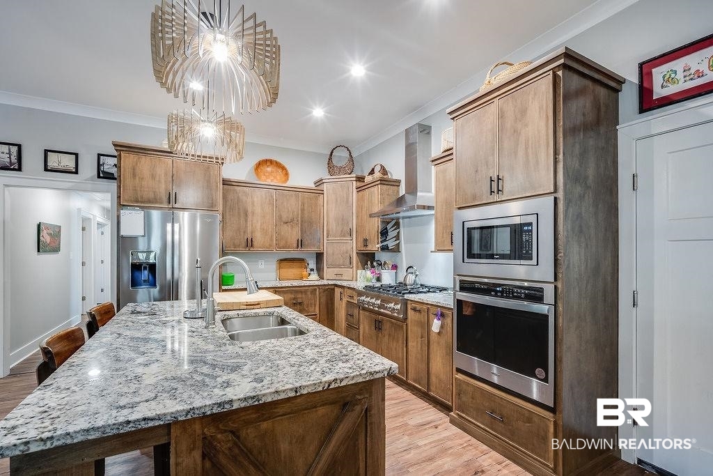 7420 Pake Road Saraland, AL 36571 - Photo 8 of 35 Kitchen with wall chimney exhaust hood, ornamental molding, a sink, and stainless steel appliances