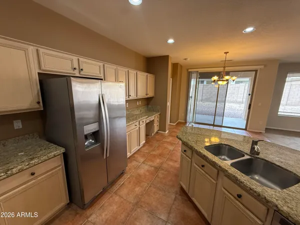 a kitchen with granite countertop a refrigerator and a sink