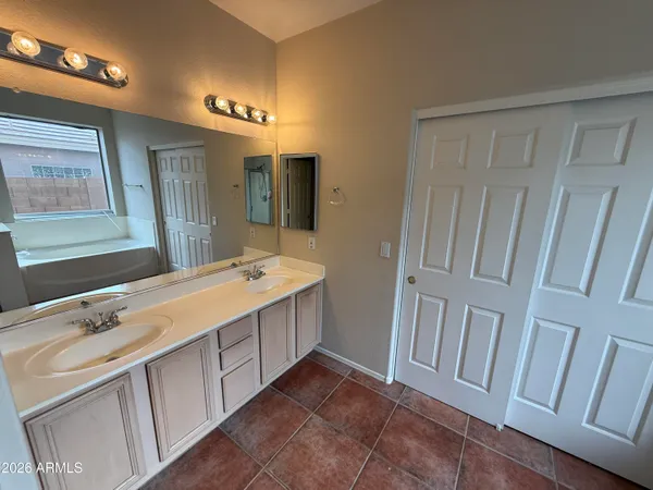 a spacious bathroom with a double vanity sink a large mirror and a shower