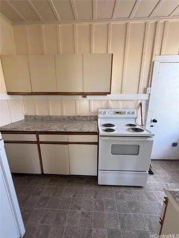 a kitchen with granite countertop white cabinets and white appliances