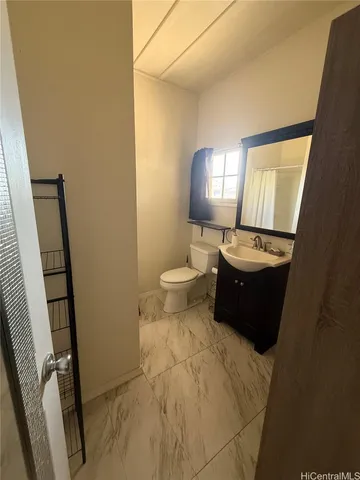 a bathroom with a toilet a sink a mirror and vanity
