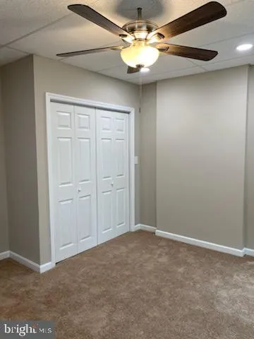 an empty room with a chandelier fan