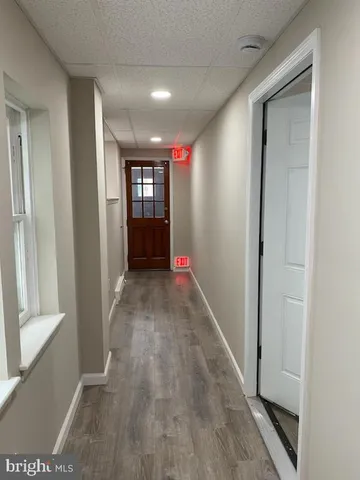 a view of a hallway with wooden floor and a living room