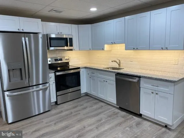 a kitchen with granite countertop stainless steel appliances and wooden cabinets