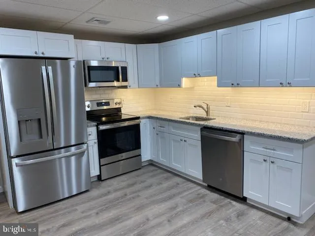 a kitchen with granite countertop stainless steel appliances and wooden cabinets