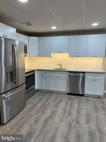 a kitchen with granite countertop a refrigerator and a sink