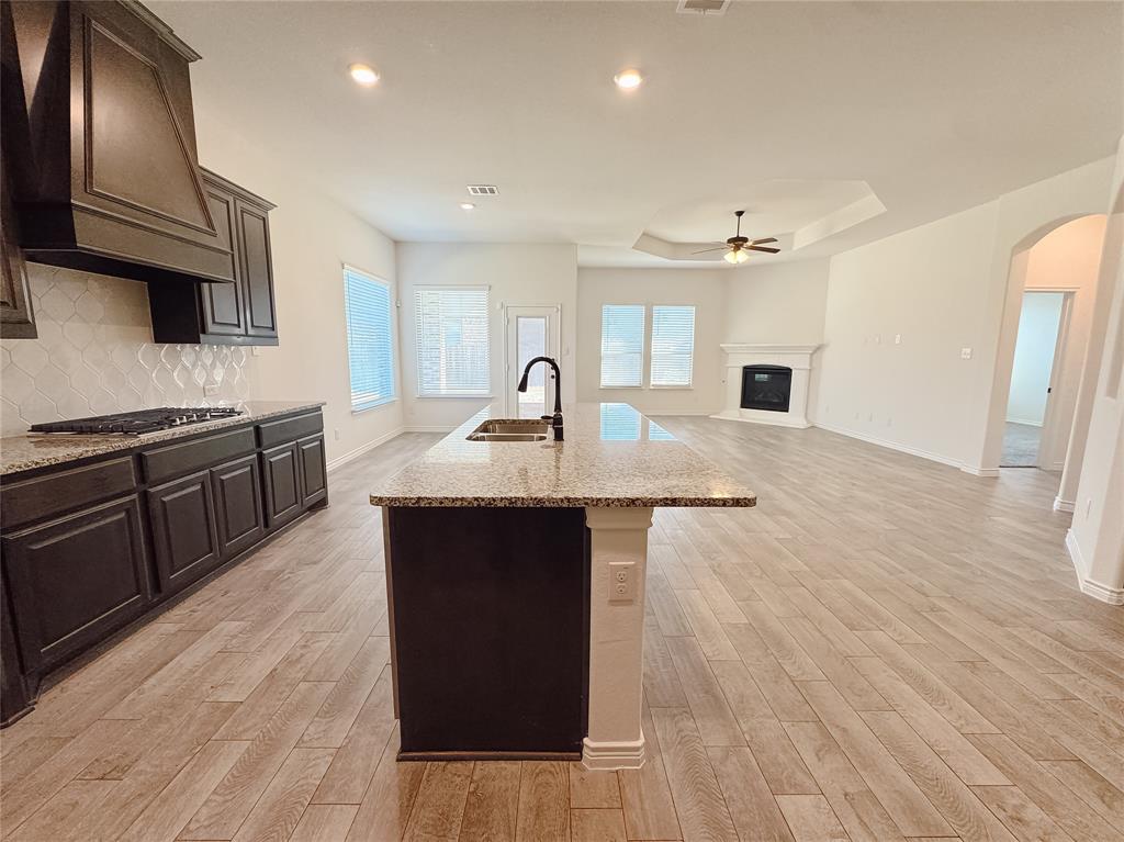 1076 Sublime Drive Forney, TX 75126 - Photo 16 of 40 a kitchen with kitchen island granite countertop a sink stove and refrigerator