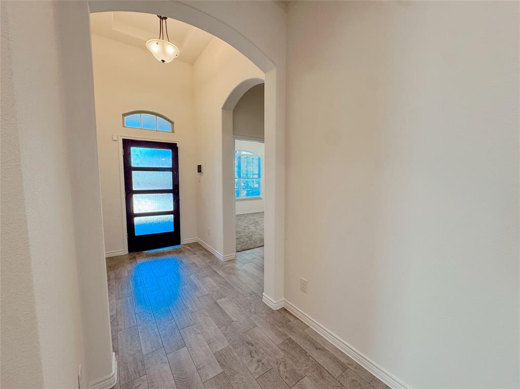 1076 Sublime Drive Forney, TX 75126 - Photo 5 of 40 a view of an empty room with window and wooden floor