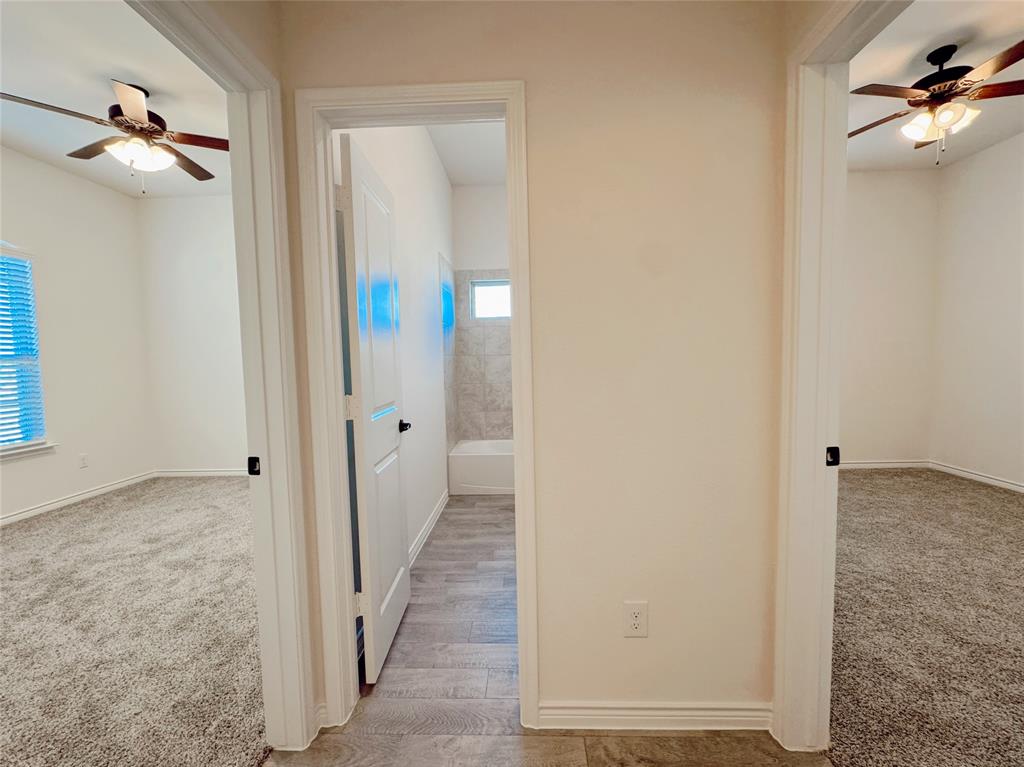 1076 Sublime Drive Forney, TX 75126 - Photo 6 of 40 a view of a hallway with a chandelier fan and wooden floor