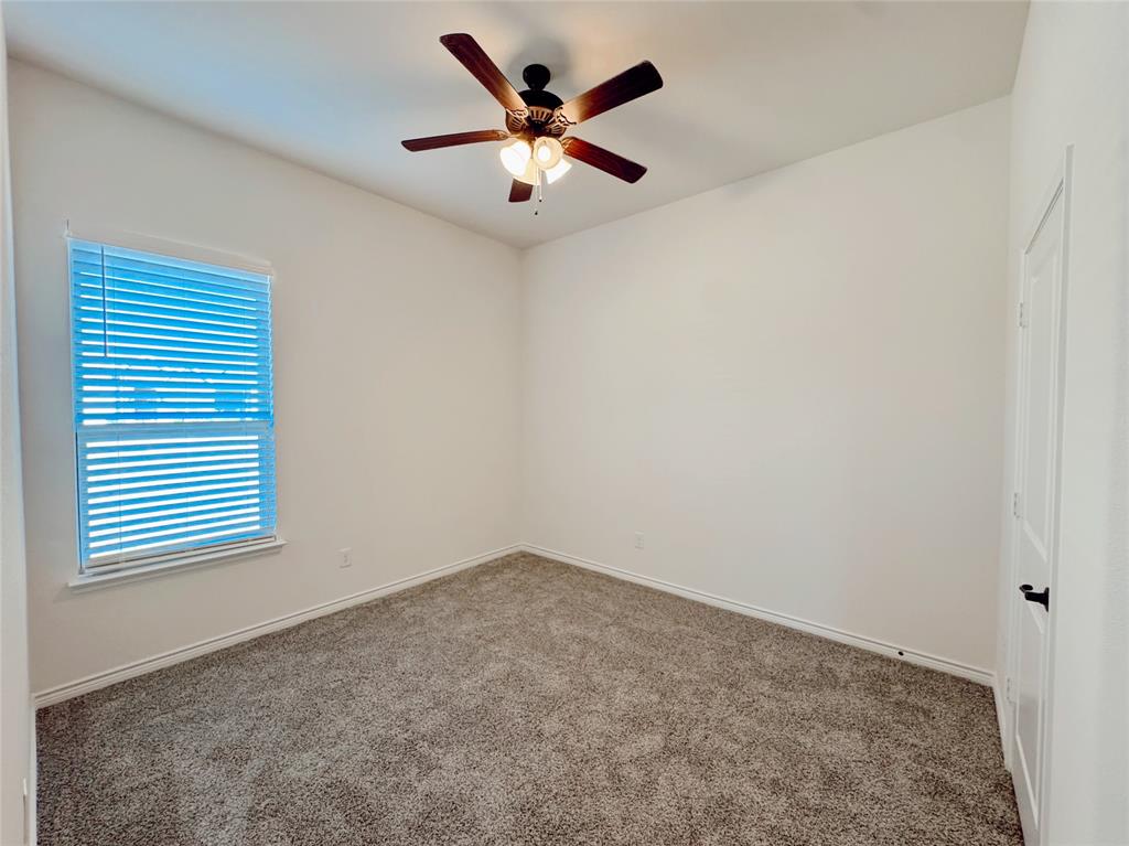 1076 Sublime Drive Forney, TX 75126 - Photo 7 of 40 an empty room with a window and a ceiling fan